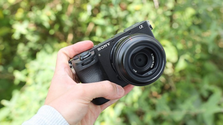 Компактная камера Sony A6400 с объективом в руке
