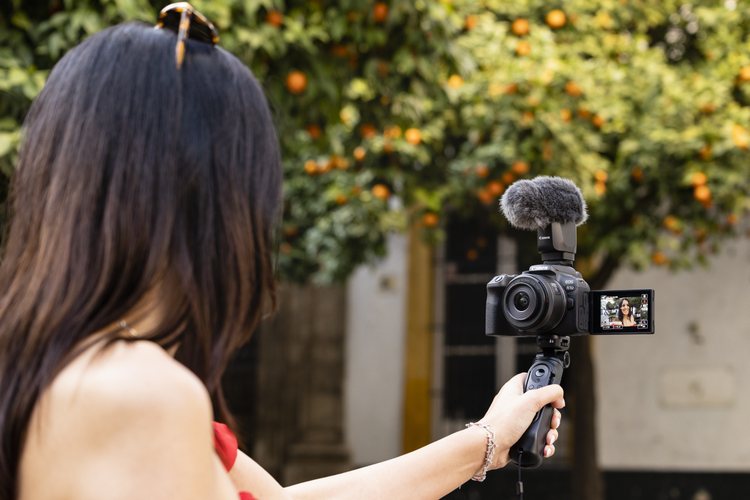 Canon EOS R10 на рукоятке во время съёмки на улице