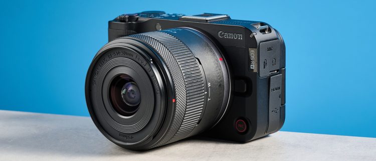 Canon EOS R50 V с объективом RF-S на голубом фоне
